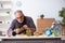 Old male watchmaker working in the workshop