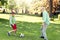 Old man and boy playing football at summer park