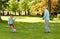 Old man and boy playing football at summer park