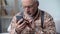 Old man cautiously using smartphone, learning apps and new technologies, closeup