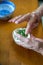 An old man in a Chinese family makes dumplings by hand