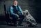 Old man dressed in suit posing on armchair and his dog