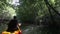 old man drifts on kayak down river among jungle