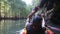 old man drifts on kayak through over-hanging grotto