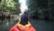 old man drifts on kayak under over-hanging cliffs