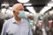 Old man in face mask at entrance to metro station