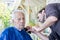 Old man getting his beard shaved by young skilled man at home