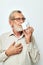 old man in glasses with a mug on a white background joyful