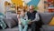 Old man grandfather reading book to smart grandchild indoors in apartment