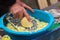 Old man grates a squash. Hands hold grater and vegetable