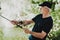 Old Man with Gray Hair Fishing on River in Summer.