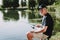 Old Man with Gray Hair Fishing on River in Summer.