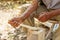 Old man handcrafting a wood spoon the traditional way of making tools in the villages of Romania and Eastern Europe