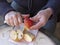 Old man hands peeling organic red Pink Lady apple outside over a bowl of apple slices