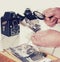 Old man hands, view photos with magnifying glass from the past, retro cameras on the table, filtered