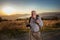 Old man just reaches the top of hill.Handsome senior man hiking, exploring, holding digital tablet