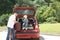 Old man and kid loads his red car suitcases