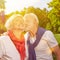 Old man kissing senior woman on cheek