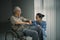 Old man laughing with his nurse near the window