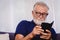 Old man looking at the smartphone for reading news update or playing social network apps