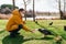 Old man with a medical mask feeding a duck on the grass