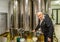 Old man opens tap of storage silo of olive oil