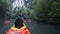 old man paddles on kayak to cliff among jungle