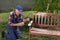 Old man painting bench in garden