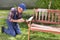Old man painting bench in garden