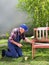 Old man painting bench in garden