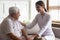 Old man patient and careful nurse or caregiver communication indoors
