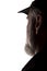 Old man in peaked cap, side view - dark close-up silhouette