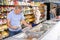 Old man purchaser choosing frozen fish in big supermarket