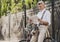 Old man Reading Newspaper near Bicycle in Park.