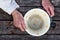 Old man`s hands hold an empty old bowl