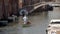 Old man sail in a canal in Venice with his little boat.