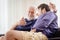 Old man serious discussion with younger man indoor, grand father serious talking with his son at home