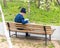 An old man is sitting on a bench