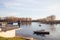 Old man standing and meditating in front of the port of Kovin, on the Danube, with boats