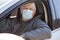 Old man taxi driver with one-use medical mask, portrait