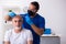 Old man visiting young male doctor in hair transplantation conce