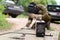 Old man welder in brown uniform, welding mask and welders leathers, weld metal door with arc welding machine outdoors