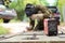 Old man welder in brown uniform, welding mask and welders leathers, weld metal door with arc welding machine outdoors