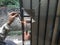 Old Man Welding a Corrosive Black Iron Handle of Gate