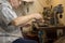 Old Man Working Electronic Device on Small Table