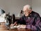 Old man working on a vintage sewing machine on a wooden table