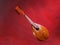 Old mandolin located diagonally on a bright red background. Baroque string musical instrument