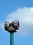 Old mechanical warning siren on a pole against a blue cloudy sky