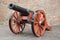 Old medieval artillery canon before a brick wall