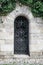 Old medieval black metal door with cerved bar and